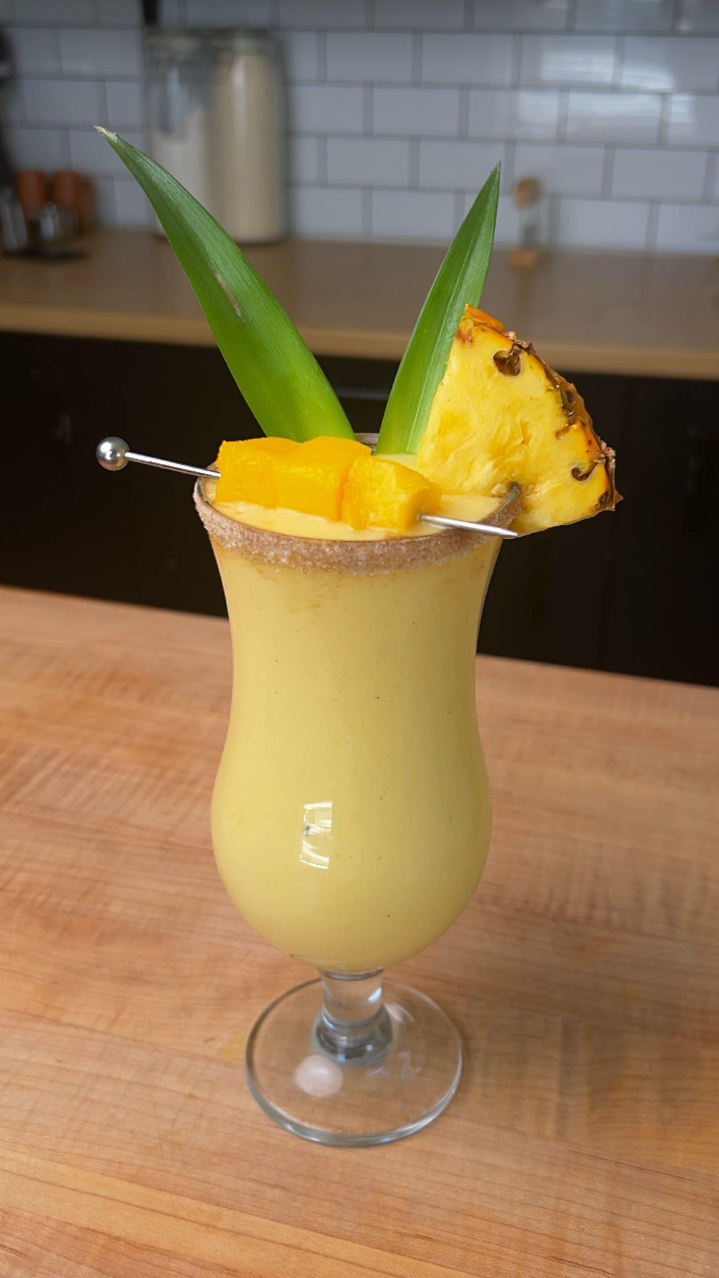 a refreshing coconut pineapple lassi in a glass with tropical garnish