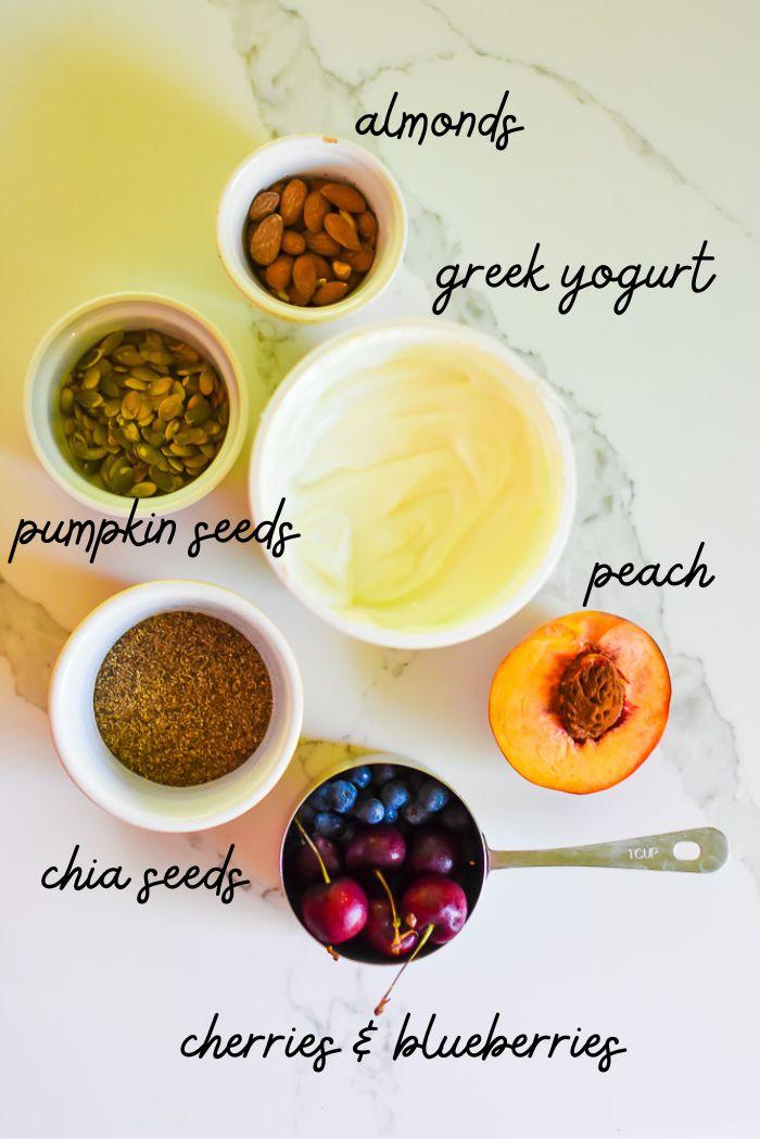 Ingredients for kumquat yogurt parfait laid out on a wooden table