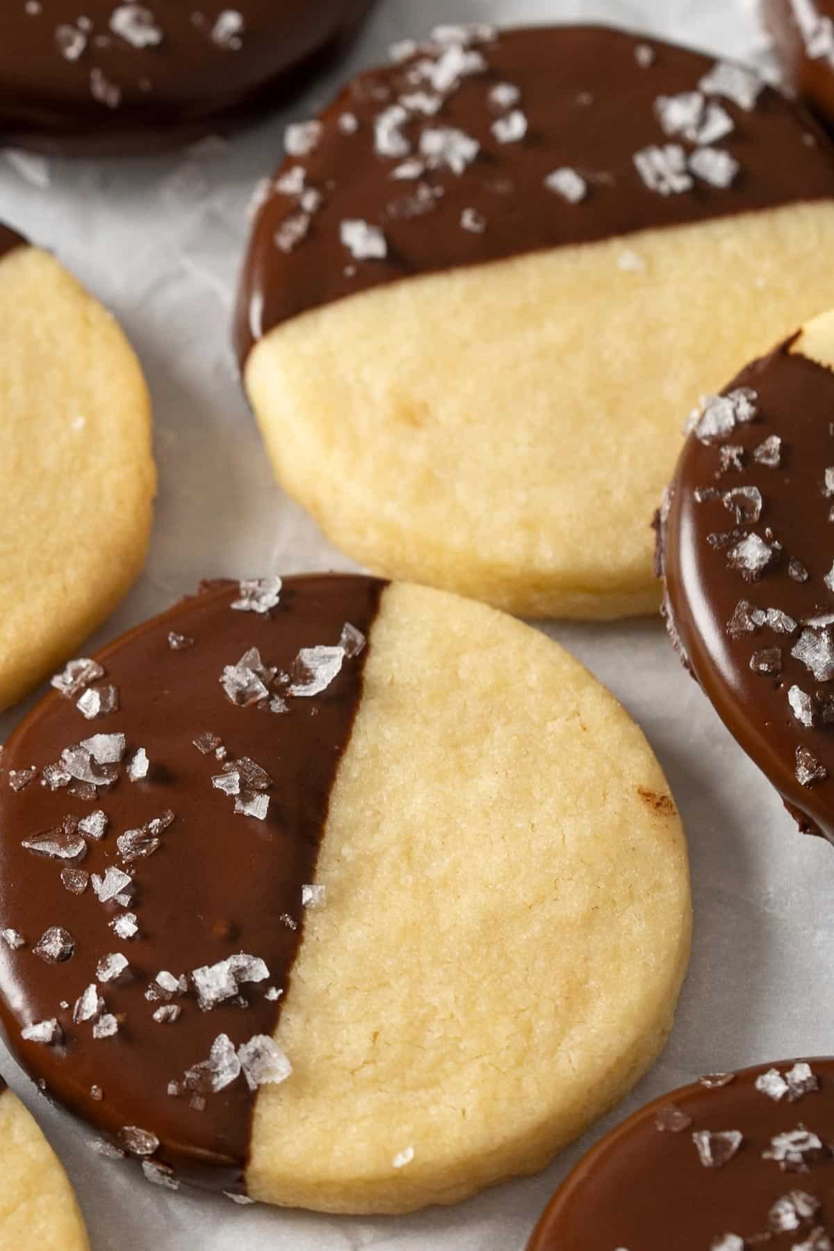 plate of glistening chocolate-dipped shortbread cookies with crumbs, cozy kitchen lighting