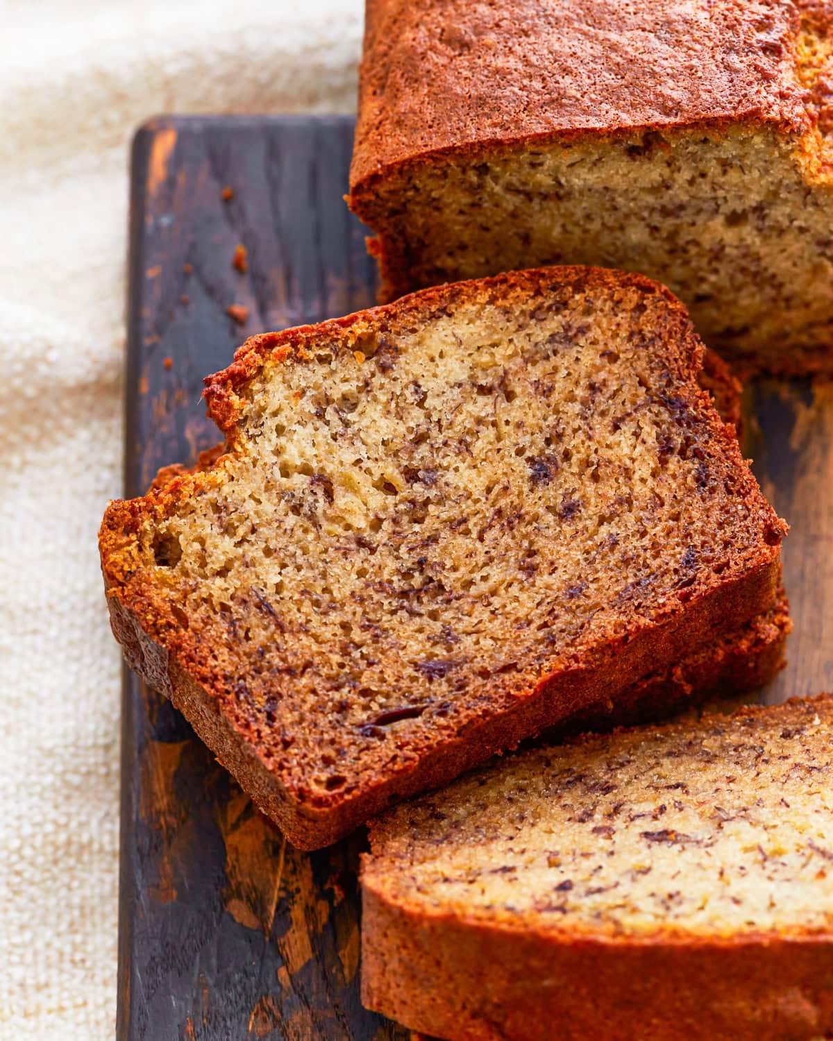 close-up of a hand slicing a piece of gluten-free banana bread