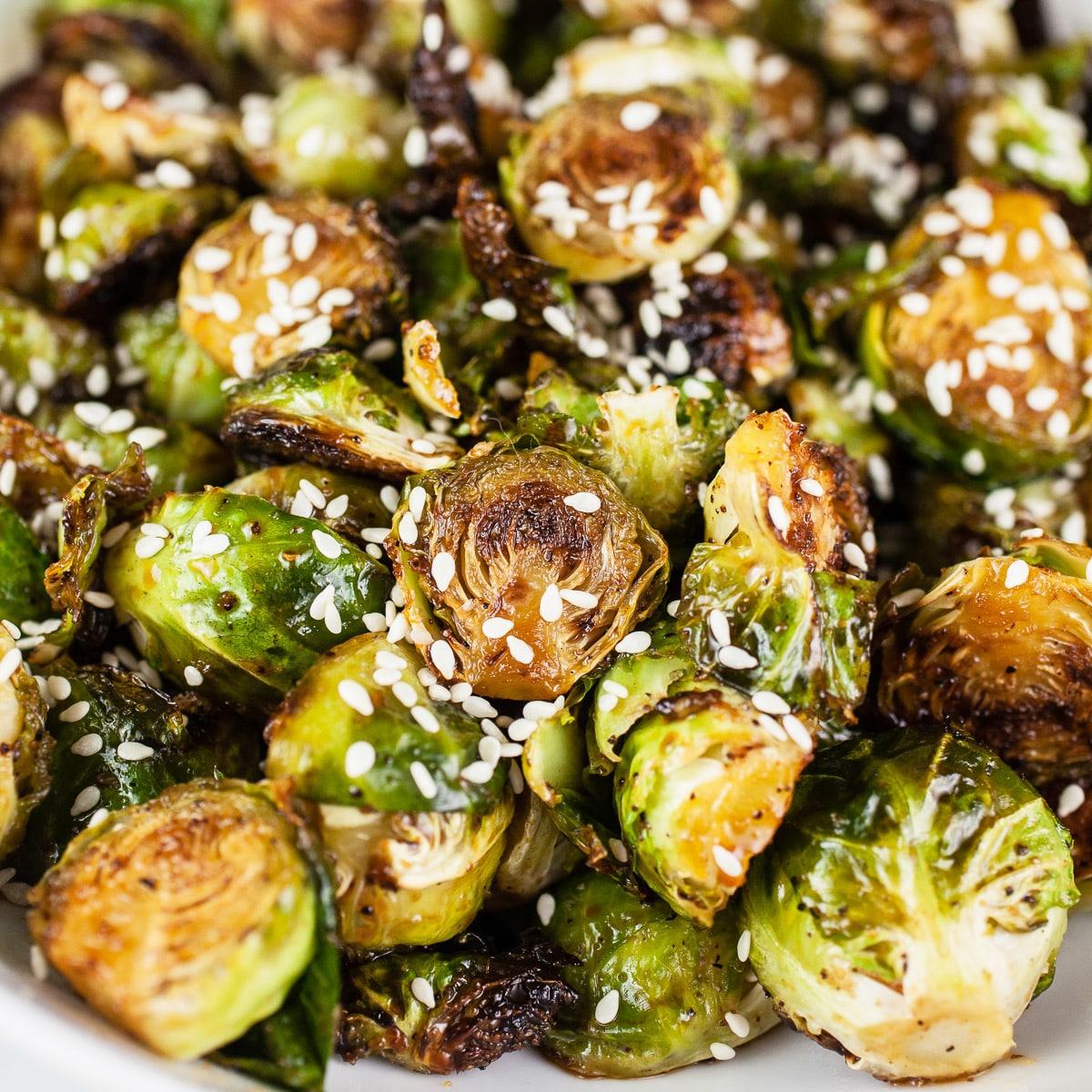 roasted brussels sprouts with sesame seeds and rice vinegar on a plate